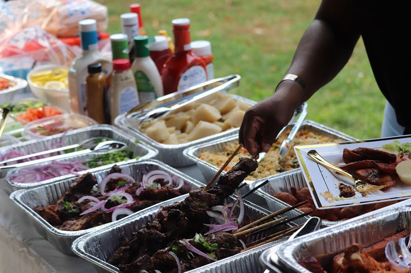 Multiple foods across a picnic table outdoors